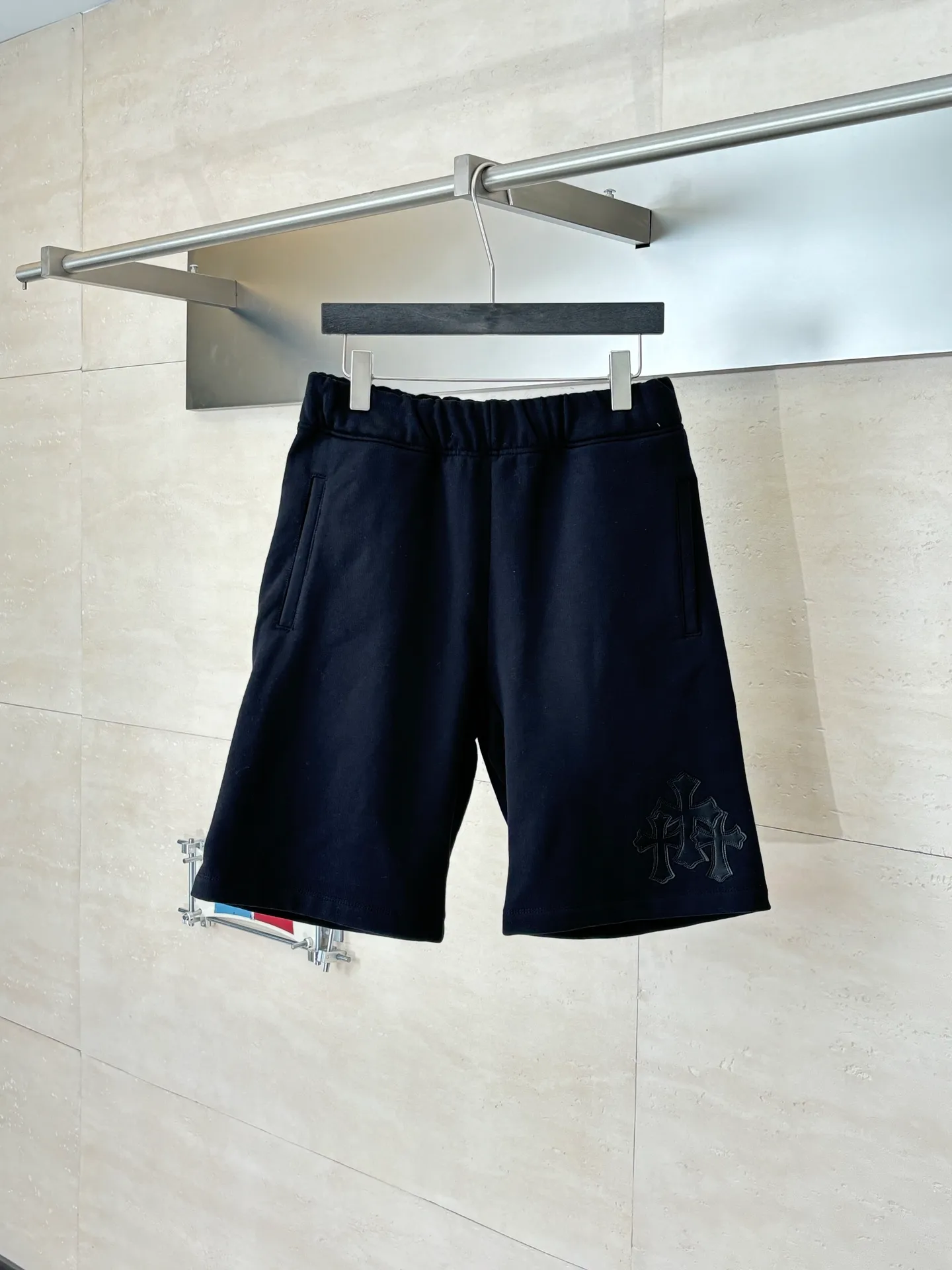 P346 Chrome Hearts*/Chrome Hearts 26SS early spring new patch embroidered shorts The fabric is made of a blended ratio of 80% cotton and 20% polyester. It is woven with a siro spinning process of 32-count base yarn and 10-count veil to form a high-weight terry cloth base of 380g/㎡. The cotton-polyester blended material combines the skin-friendly breathability of cotton and the anti-wrinkle shape retention of polyester. The high-weight fabric gives the trousers excellent stiffness and drape. The core technology is patch embroidery, which is completed with the help of TAJIMA computer embroidery machine. The black special-shaped patch is precisely sewn to the trouser fabric through lock stitches. The embroidery stitch density is even and the edges are neatly hemmed, forming a three-dimensional relief-like visual effect. Size: S/M/L/XL